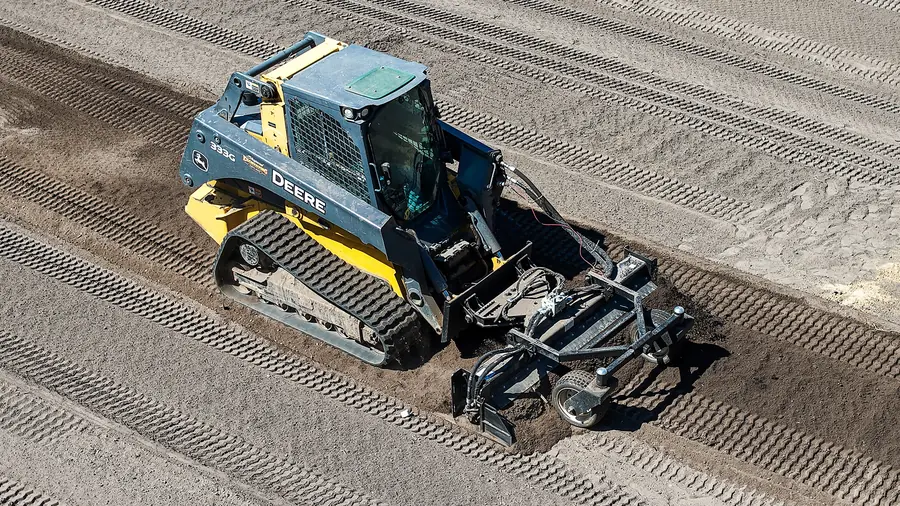Aerial of a Deere 333G track loader with a power rake